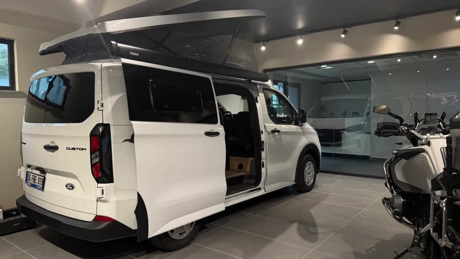 Ford Transit Custom Assos in der Heckansicht mit Thule-Markise und ausgestelltem Aufstelldach