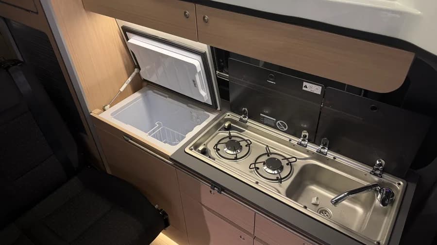 Küchendetail mit geöffnetem 40-l-Kompressorkühlschrank von Indel, Dometic-Kocher und Spüle