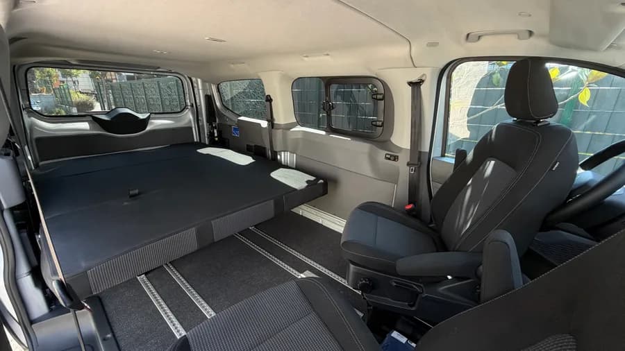 Innenraum mit zum breiten Bett umgeklapptem STIDE-Sitzsystem und Aluminium-Bodenschienen